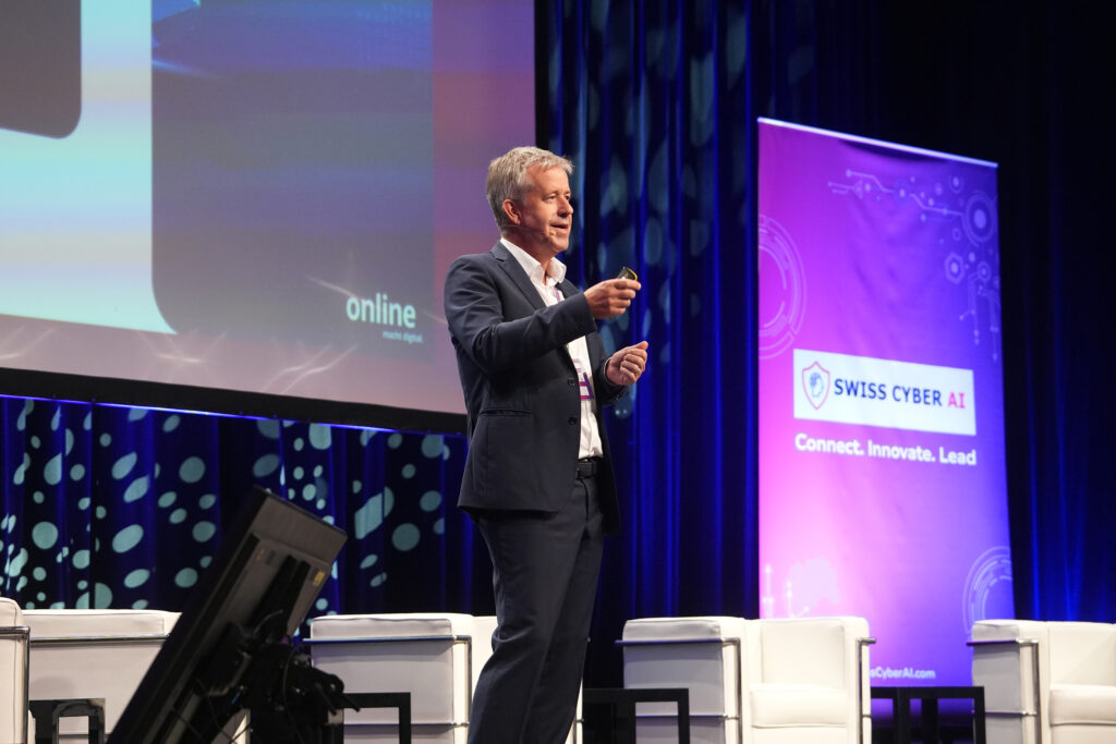 Balz Zürrer on the main stage of the Swiss Cyber AI Conference 2026.